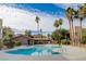 A clear in-ground pool with palm trees and apartments in the background, under a partly cloudy sky at 1846 N Decatur Blvd # 104, Las Vegas, NV 89108