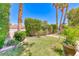 Lush backyard featuring manicured lawn, mature landscaping, and brick planter, perfect for relaxation and outdoor enjoyment at 2101 Plaza Del Fuentes, Las Vegas, NV 89102