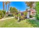 An open backyard with green lawn and patio is framed by greenery, trees, and plants at 2101 Plaza Del Fuentes, Las Vegas, NV 89102