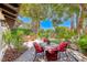 A backyard patio has a stone table and four chairs surrounded by lush landscaping at 2101 Plaza Del Fuentes, Las Vegas, NV 89102
