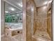 A tiled shower and soaking tub are featured in the luxurious primary bathroom with glass accents at 2101 Plaza Del Fuentes, Las Vegas, NV 89102