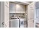 A modern laundry room features front load washer/dryer and white cabinets for plenty of storage at 2101 Plaza Del Fuentes, Las Vegas, NV 89102