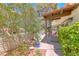 This charming side yard features a brick wall, flowering plants, and a cactus in a blue pot at 2101 Plaza Del Fuentes, Las Vegas, NV 89102