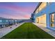 Picturesque backyard with manicured artificial lawn, complemented by desert landscaping and neighborhood views at 230 Cactus Sunrise St, Las Vegas, NV 89138