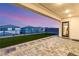 Serene backyard featuring an artificial lawn, stepping stones, and a covered patio for stylish outdoor living at 230 Cactus Sunrise St, Las Vegas, NV 89138