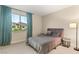 Comfortable bedroom with a plush bed, two end tables, a floor lamp, and an oversized window with blue curtains at 230 Cactus Sunrise St, Las Vegas, NV 89138