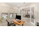 Well-lit home office space with a wooden desk, three windows, and glass doors at 230 Cactus Sunrise St, Las Vegas, NV 89138
