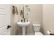 Modern powder room featuring a pedestal sink, oval mirror, and elegant fixtures at 230 Cactus Sunrise St, Las Vegas, NV 89138