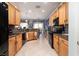 Open kitchen layout with wooden cabinetry, appliances, and tile flooring at 2486 Divine Sky Dr, Henderson, NV 89044