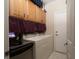 Functional laundry room with wooden cabinets and modern appliances at 2486 Divine Sky Dr, Henderson, NV 89044