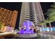 Striking night view of a modern high-rise building with illuminated water fountain feature and palm trees at 2700 Las Vegas Blvd # 1804, Las Vegas, NV 89109