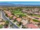 An aerial shot featuring a home in a golf course community with lush landscaping and mountain views in the distance at 2808 Crown Ridge Dr, Las Vegas, NV 89134