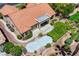 Aerial view of a well-maintained home featuring a tile roof, a unique patio, and lush landscaping at 2808 Crown Ridge Dr, Las Vegas, NV 89134