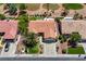 This aerial view highlights a house with a tile roof, palm trees, and a well-maintained lawn in a golf course community at 2808 Crown Ridge Dr, Las Vegas, NV 89134