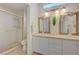 Elegant bathroom with a double vanity, decorative mirrors, and a tiled shower at 2808 Crown Ridge Dr, Las Vegas, NV 89134