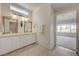 Bright bathroom with double sinks, decorative mirrors, and an open doorway to a bedroom at 2808 Crown Ridge Dr, Las Vegas, NV 89134
