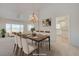 Formal dining room features neutral paint, a modern chandelier, and is open to the living room and kitchen at 2808 Crown Ridge Dr, Las Vegas, NV 89134