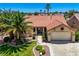 Inviting single-Gathering home showcasing a tile roof, lush palm trees, meticulously maintained landscaping, and a two-car garage at 2808 Crown Ridge Dr, Las Vegas, NV 89134