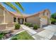 Inviting home exterior with a tile roof, stone accents, and lush landscaping at 2808 Crown Ridge Dr, Las Vegas, NV 89134