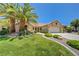Charming single-story home with a well-manicured lawn and mature palm trees at 2808 Crown Ridge Dr, Las Vegas, NV 89134