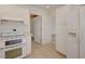 Bright kitchen with white appliances, cabinetry and tile flooring is conveniently connected to other rooms at 2808 Crown Ridge Dr, Las Vegas, NV 89134