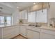 Well-lit kitchen with white countertops, cabinets, sink, and stainless steel appliances overlooking a bay windowed breakfast nook at 2808 Crown Ridge Dr, Las Vegas, NV 89134