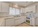 Bright kitchen features all-white cabinetry, countertops, tile flooring and stainless steel appliances at 2808 Crown Ridge Dr, Las Vegas, NV 89134
