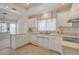 Well-lit kitchen with white countertops, cabinets, sink, and stainless steel appliances overlooking a bay windowed breakfast nook at 2808 Crown Ridge Dr, Las Vegas, NV 89134