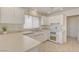 Bright kitchen features all-white cabinetry, countertops, tile flooring and stainless steel appliances at 2808 Crown Ridge Dr, Las Vegas, NV 89134