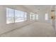 Spacious living room featuring large windows, a charming window seat, and neutral carpet at 2808 Crown Ridge Dr, Las Vegas, NV 89134