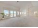 Spacious living room featuring vaulted ceilings, neutral carpet, and a view of the backyard at 2808 Crown Ridge Dr, Las Vegas, NV 89134