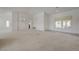 Open living room features neutral carpet, high ceilings, chandelier, and glimpses of the kitchen at 2808 Crown Ridge Dr, Las Vegas, NV 89134