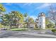 View of the community entrance with a Spanish style architecture and lush landscaping at 3220 Calle De El Cortez, Las Vegas, NV 89102