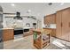 Bright kitchen features wooden cabinets, an island, and stainless steel appliances, offering a modern design at 3220 Calle De El Cortez, Las Vegas, NV 89102
