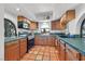 Charming kitchen featuring wood cabinets, tile floors, and a view of the lush outdoor surroundings at 3220 Calle De El Cortez, Las Vegas, NV 89102