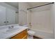 Clean bathroom with white tiled shower-tub, wood vanity, and contemporary fixtures at 350 S Durango Dr # 103, Las Vegas, NV 89145