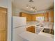 Well-equipped kitchen featuring oak cabinets, white appliances, and functional layout at 350 S Durango Dr # 103, Las Vegas, NV 89145