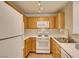 Functional kitchen featuring oak cabinets, white appliances, and a practical design at 350 S Durango Dr # 103, Las Vegas, NV 89145