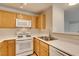 Functional kitchen featuring light wood cabinetry, white countertops, and essential appliances at 350 S Durango Dr # 103, Las Vegas, NV 89145