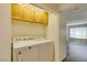 Convenient laundry area with washer and dryer, overhead cabinets, and view into living area at 350 S Durango Dr # 103, Las Vegas, NV 89145