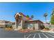 Beautiful community clubhouse showcasing inviting desert landscaping, arched entryway, and ample parking at 3608 Quetonia St # 204, Las Vegas, NV 89108
