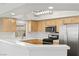 Modern kitchen featuring wood cabinets, stainless steel appliances, and a tile backsplash at 3608 Quetonia St # 204, Las Vegas, NV 89108