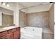 Bathroom featuring a soaking tub, tile surround, and granite countertop vanity at 4050 Pacific Harbors Dr # 224, Las Vegas, NV 89121