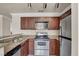 Kitchen with stainless steel appliances, wood cabinets, stylish countertops and fixtures, and modern track lighting at 4050 Pacific Harbors Dr # 224, Las Vegas, NV 89121