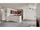 Open concept living room with fireplace next to the kitchen and breakfast bar at 4050 Pacific Harbors Dr # 224, Las Vegas, NV 89121
