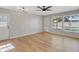 Bright living room featuring hardwood floors, modern ceiling fan, and ample natural light from the large windows at 4204 El Jardin Ave, Las Vegas, NV 89102