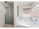 A marble tiled bathroom featuring a separate tub and shower at 4335 Twin Peaks Dr, North Las Vegas, NV 89032