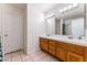 Bathroom featuring a double sink vanity with wood cabinets and a large mirror with decorative lighting at 4335 Twin Peaks Dr, North Las Vegas, NV 89032
