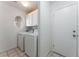 Laundry room with a white washer and dryer, a window, and access to the outside at 4335 Twin Peaks Dr, North Las Vegas, NV 89032