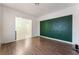 An open living room layout with wood floors and a green accent wall at 4335 Twin Peaks Dr, North Las Vegas, NV 89032